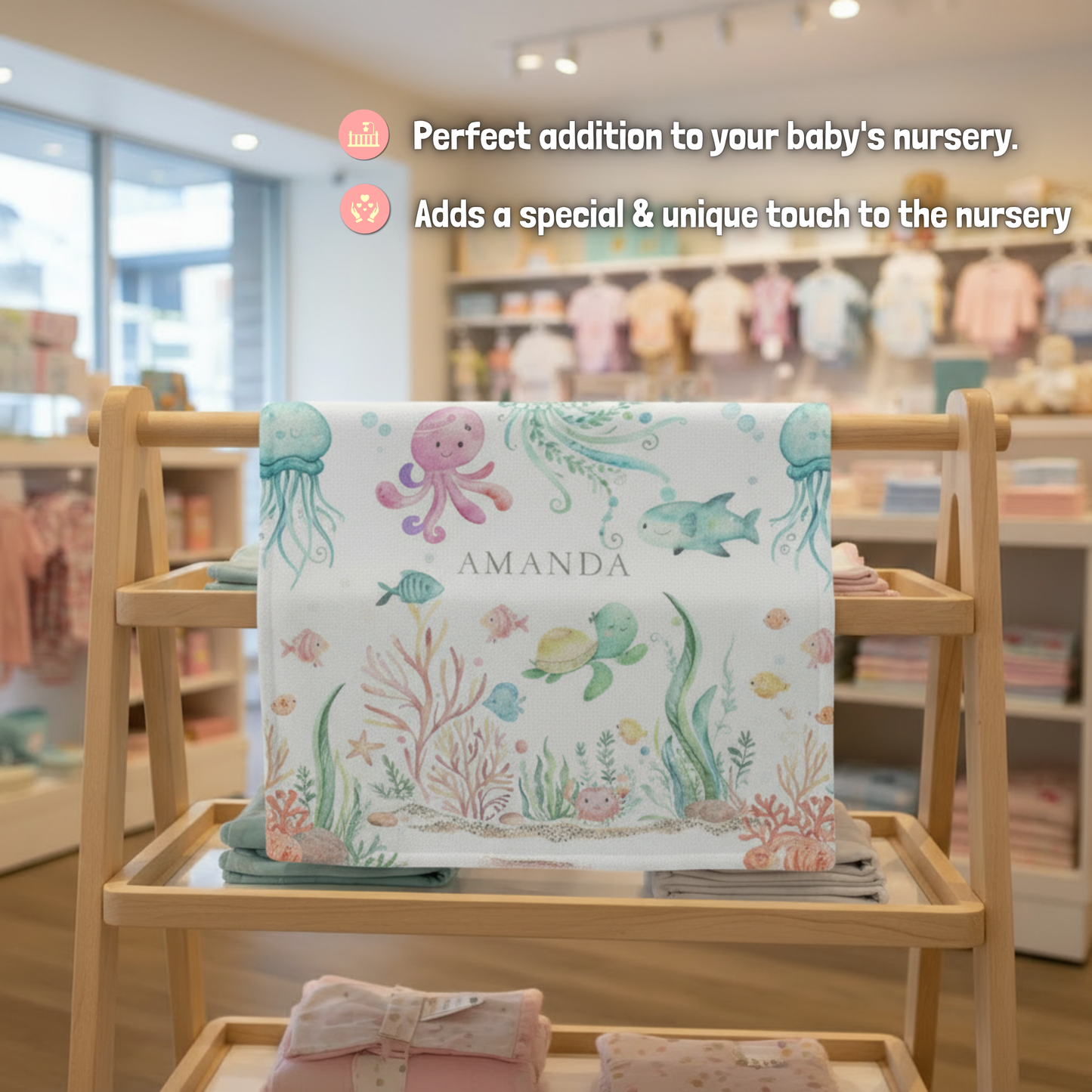 Baby blanket with ocean-themed design on a wooden high chair in a store setting