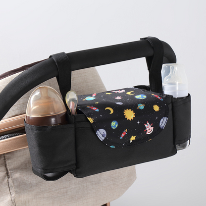 black space themed stroller organizer bag with bottle holder hung on a stroller on a white background