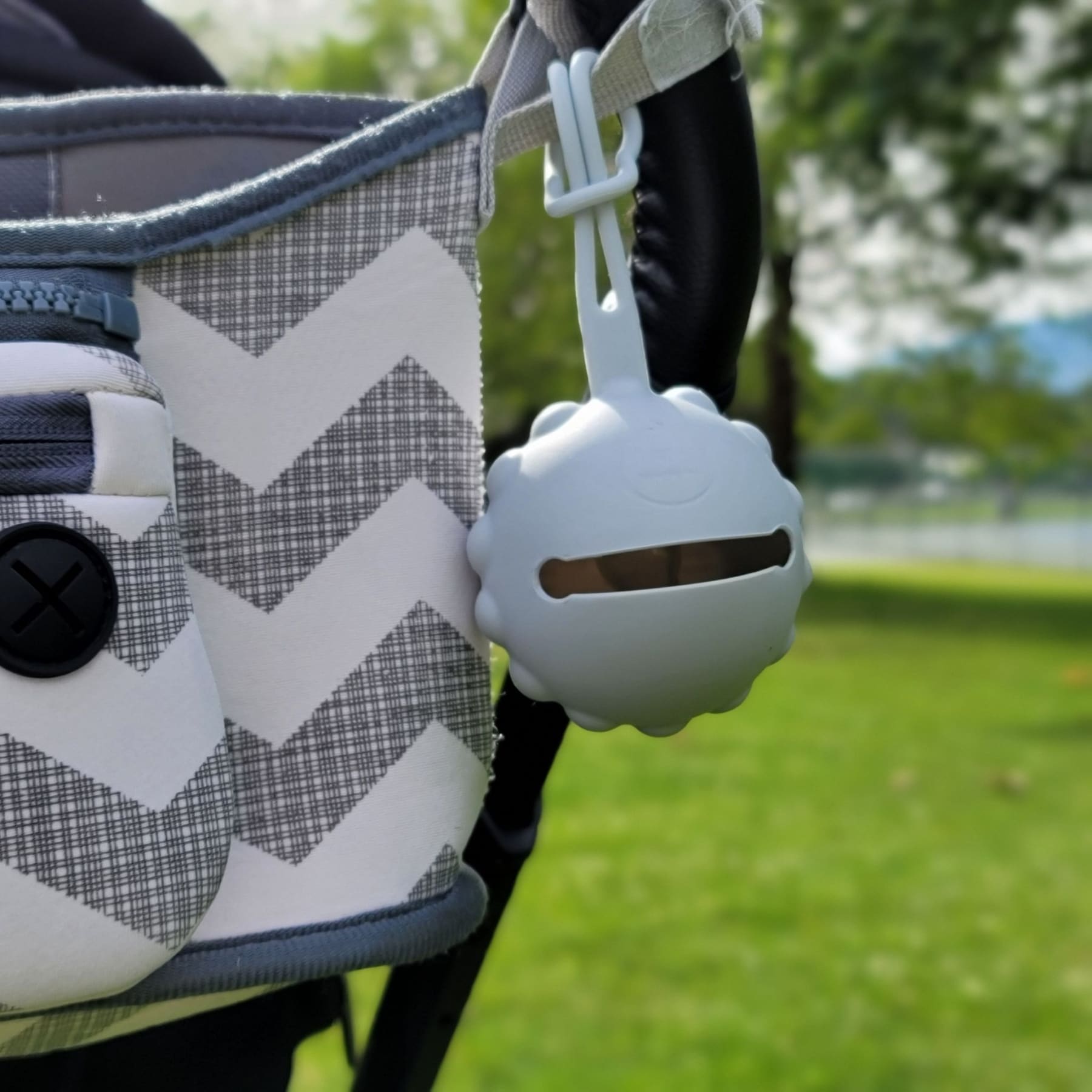 Pacifier Holder Case holding a pacifier while out for a stroll un a park.