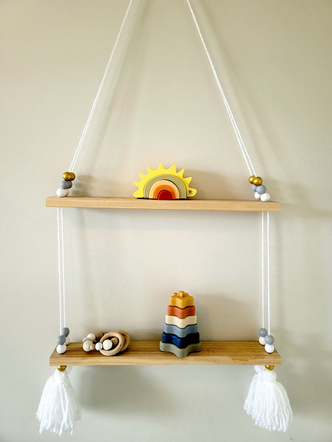Montessori stacking silicone toys on a handmade wooden shelf hung up on a wall