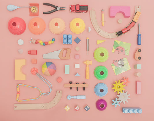 Image of wooden toys and tools for kids on a pink background 