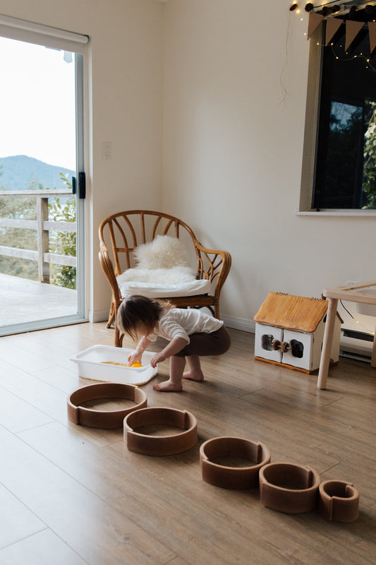 A baby playing with wooden toys in the living room of a home