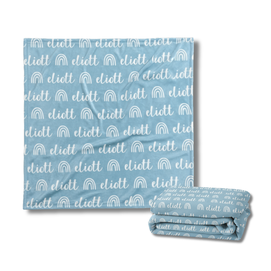 Blue blanket with white text and rainbow patterns on a white background