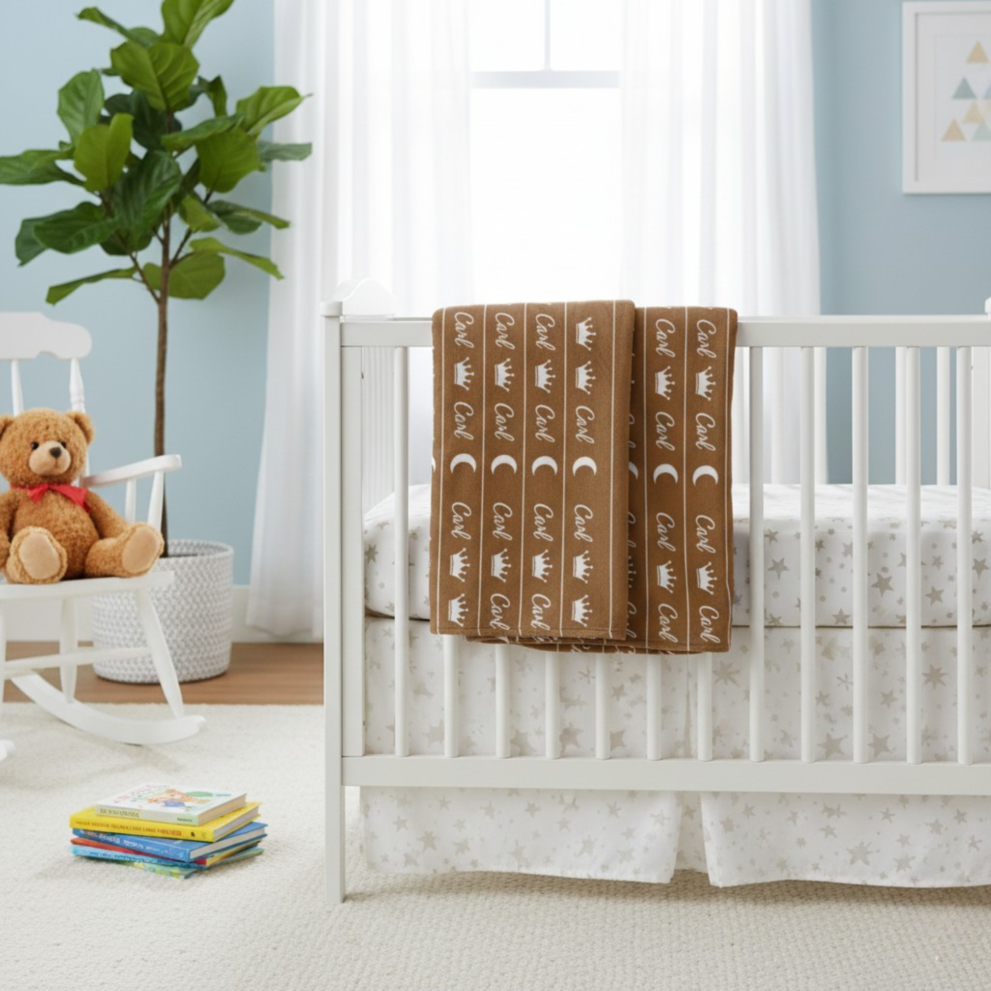 Brown personalized blanket folded and hung on rails of crib in a Nursery room with teddy bear, and books against a light blue wall.