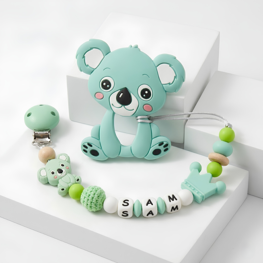 Teal koala-shaped teether with a matching personalized pacifier clip and bead chain on a white background