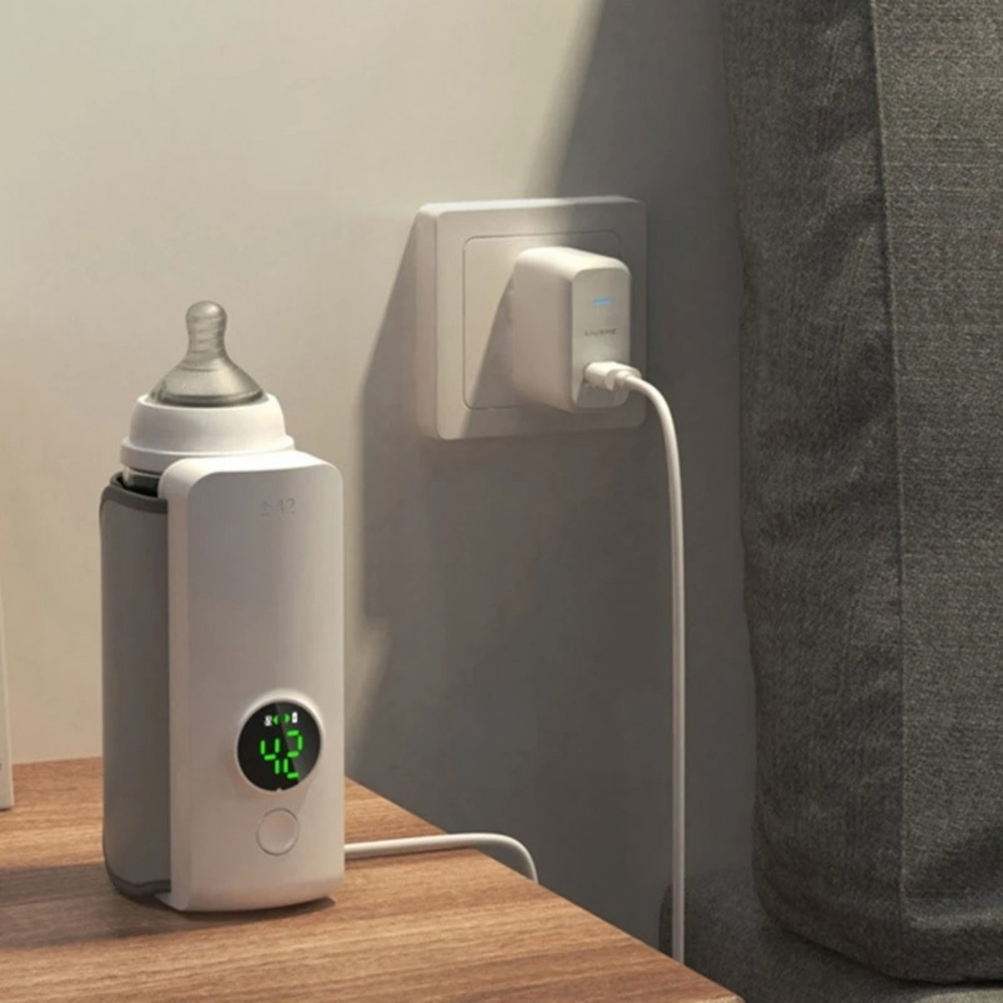 Bubba portable baby bottle warmer plugged in being charged in a room