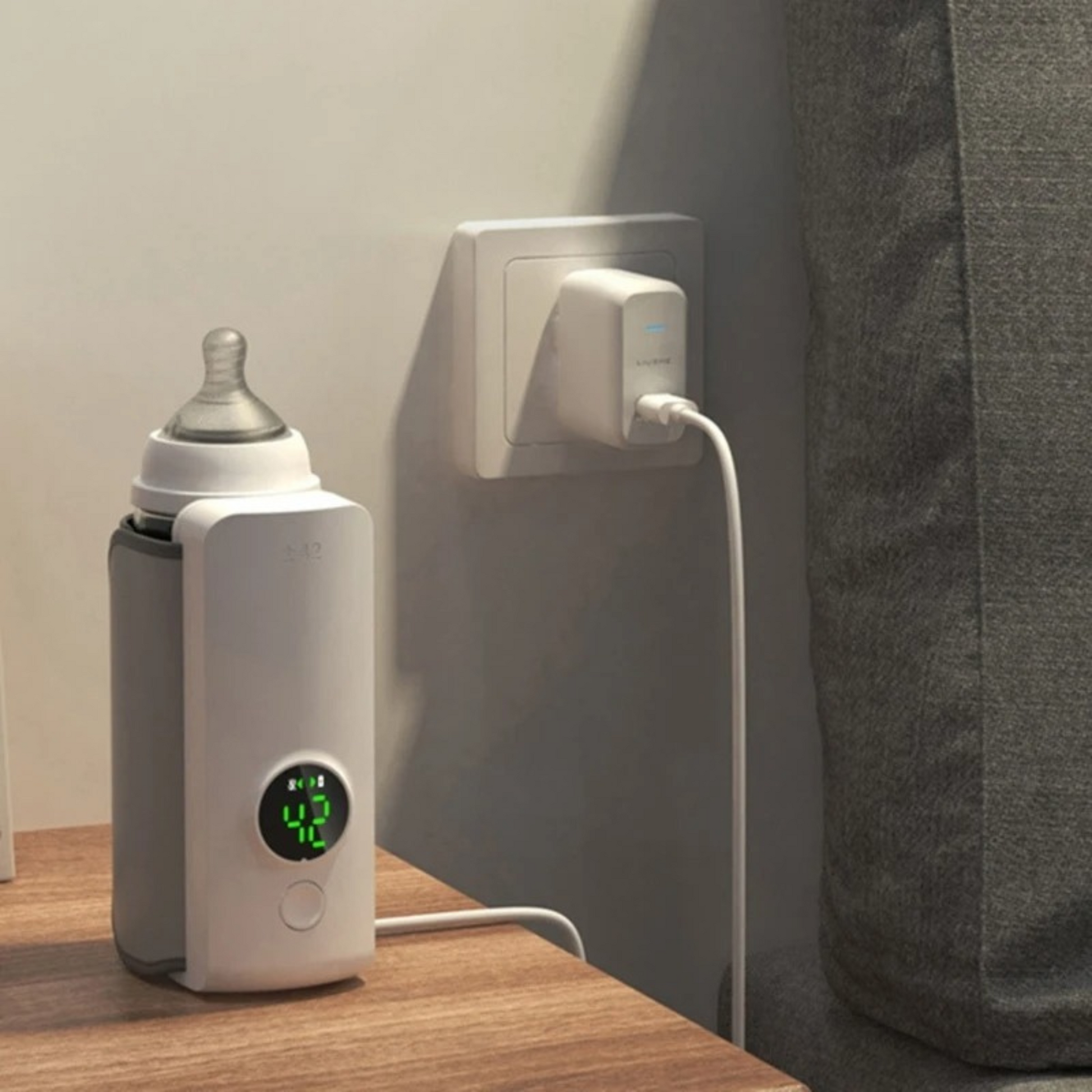 Bubba portable baby bottle warmer plugged in being charged in a room