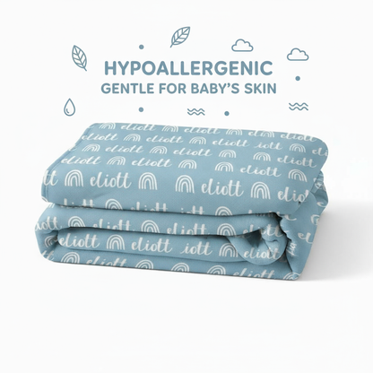 Folded blue blanket with white text and patterns on a white background, labeled as hypoallergenic for baby's skin.