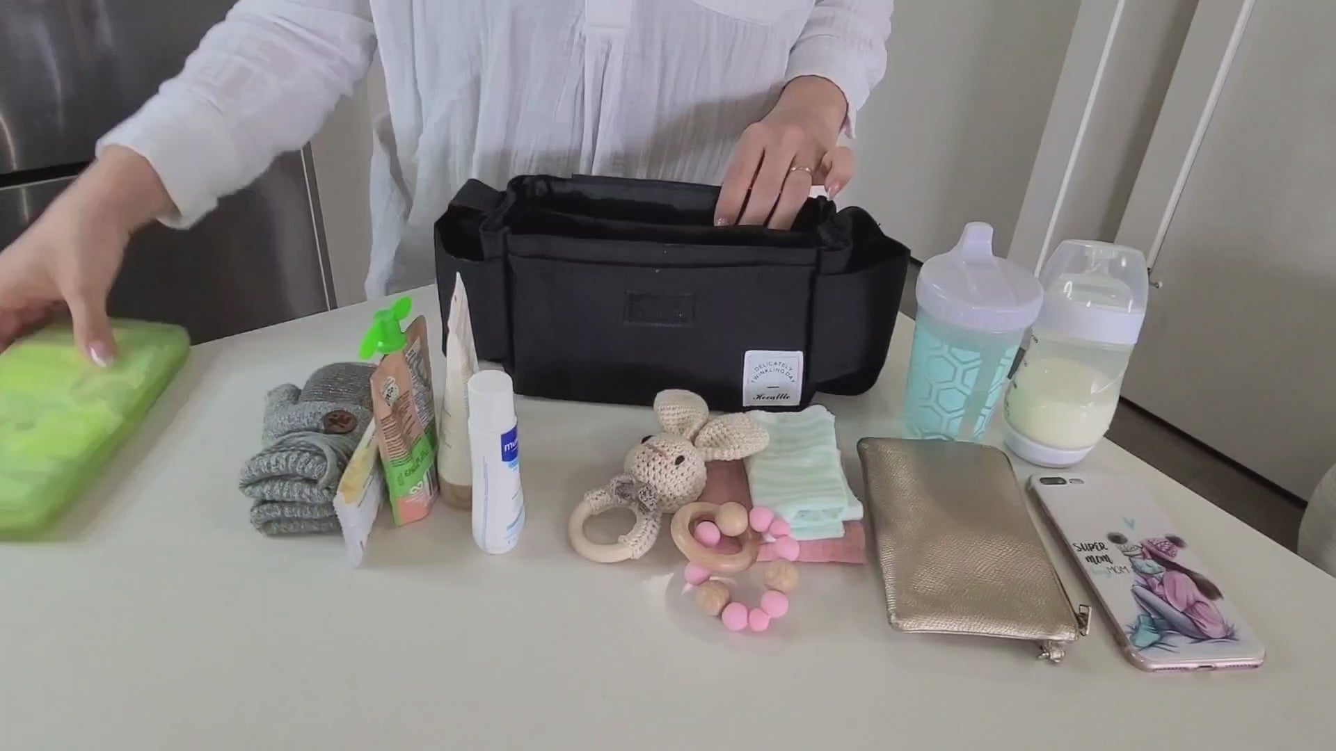 Cargar video: mother organizing all her and her baby&#39;s belongings in her stroller organizer bag and cup holder from Hunny Bubba Kids