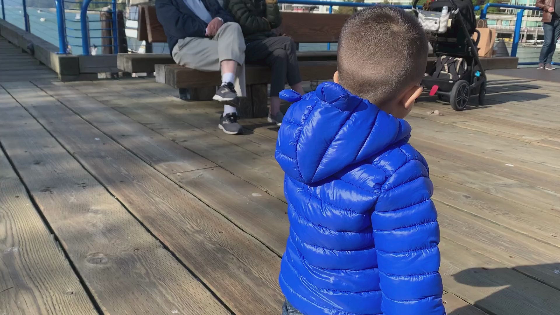 Load video: toddler boy walking by the deck wearing a soft blue puffer jacket