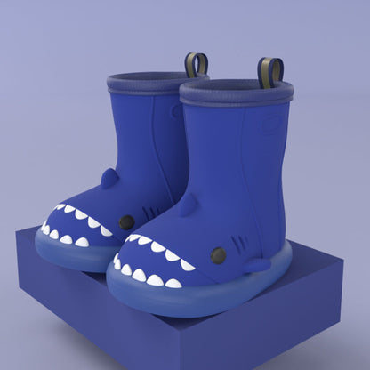 pair of royal blue shark rain boots on a yellow block for display