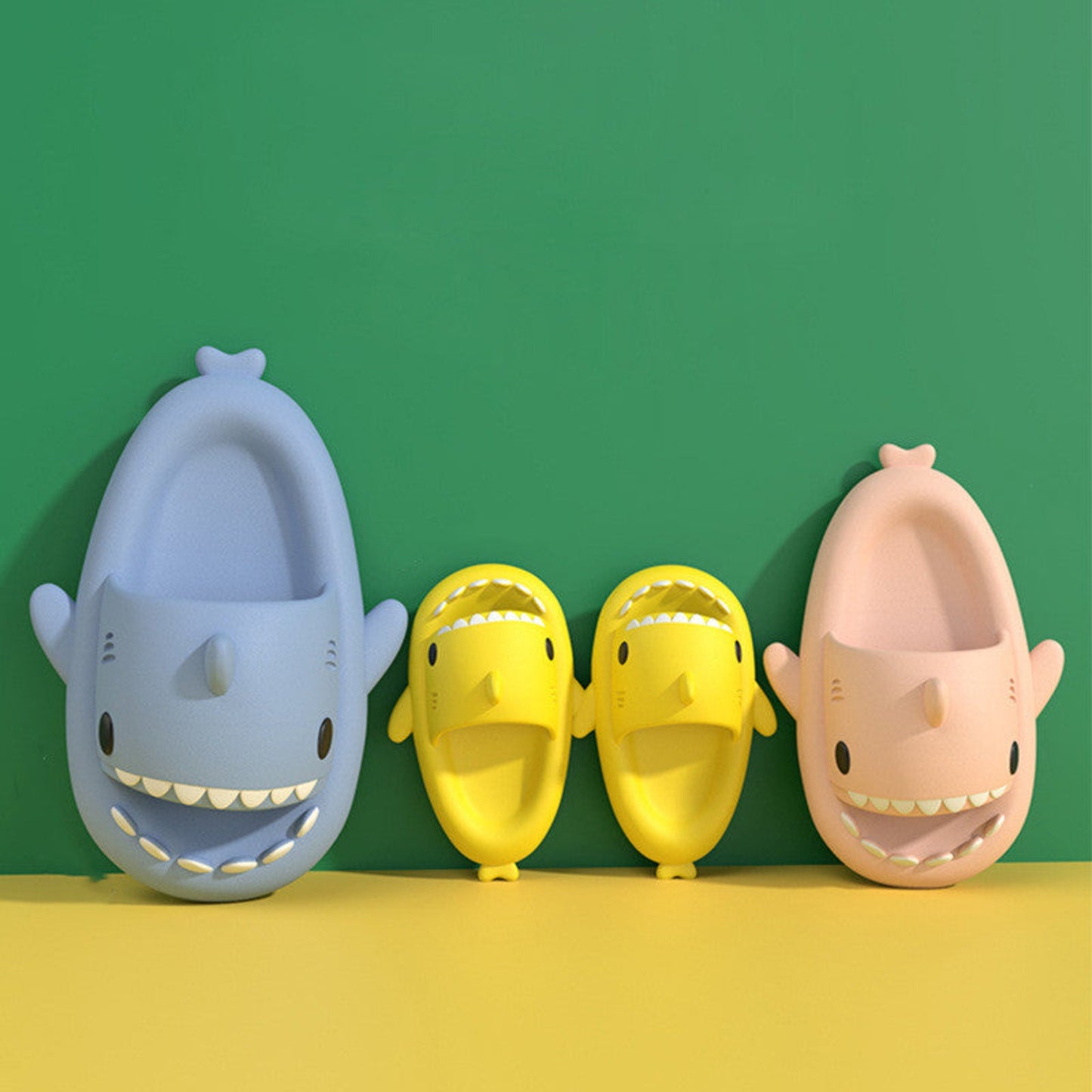 four shark slippers against a wall for summer