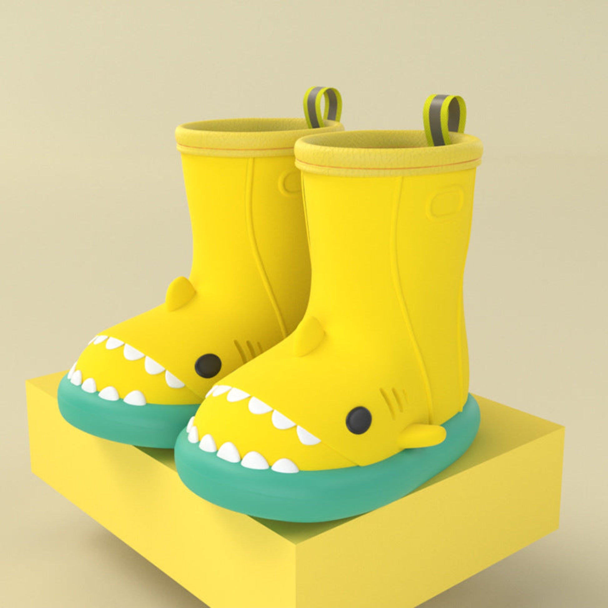 pair of yellow shark rain boots with green sole on a yellow block for display