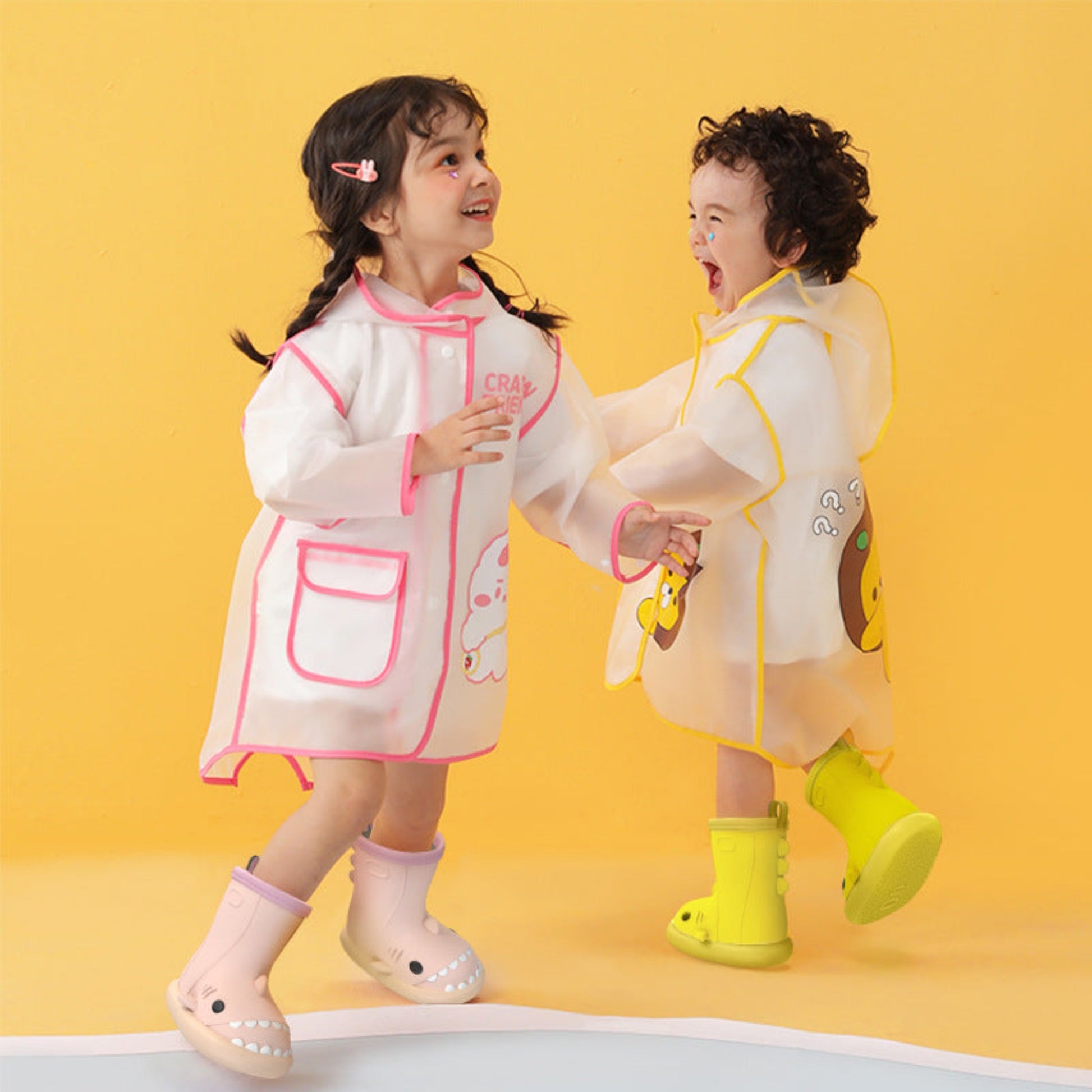 two kids smiling and playing while wearing their waterproof shark rain boots