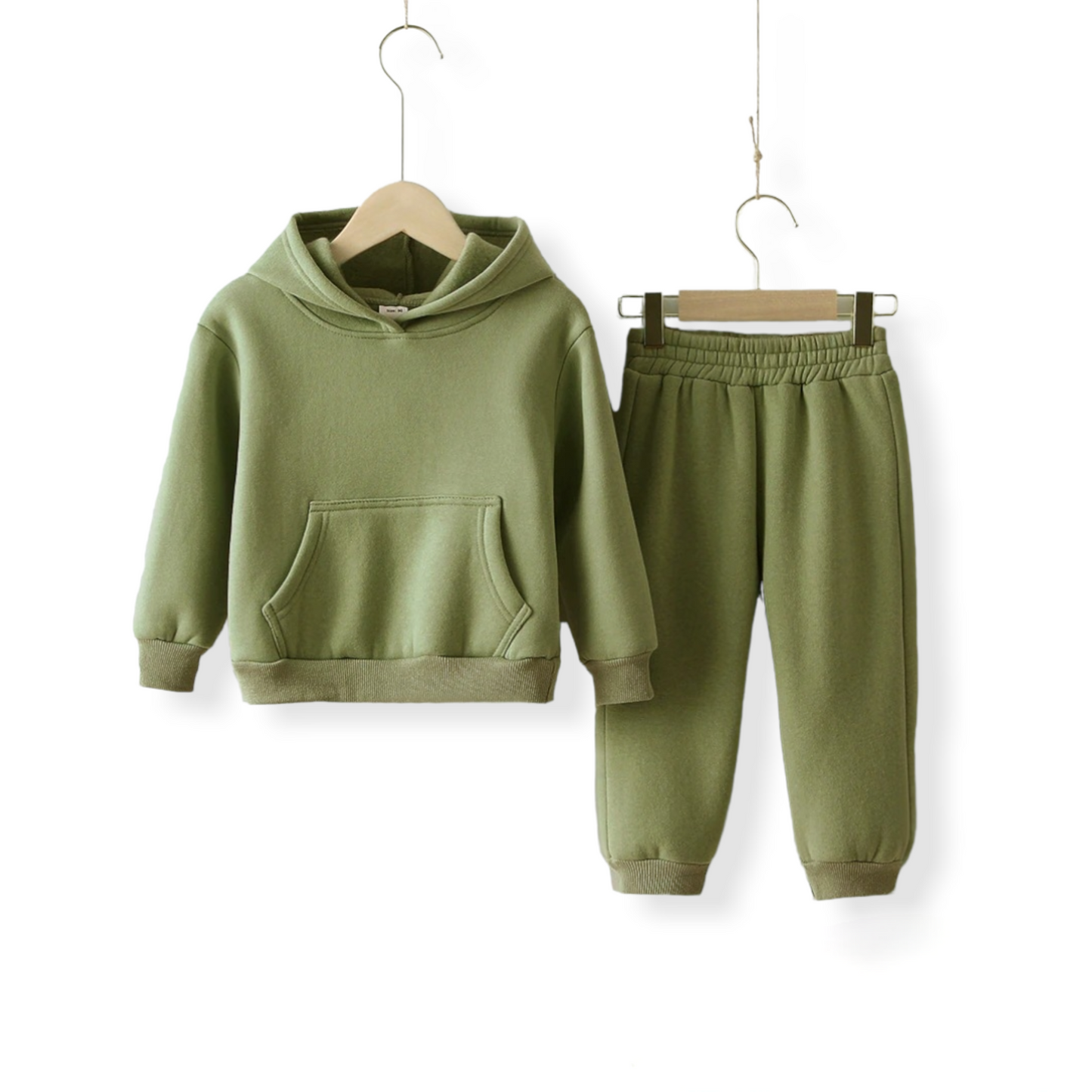 A matcha green warm unisex tracksuit for kids and toddlers hung on a hanger against a white wall from hunny bubba kids