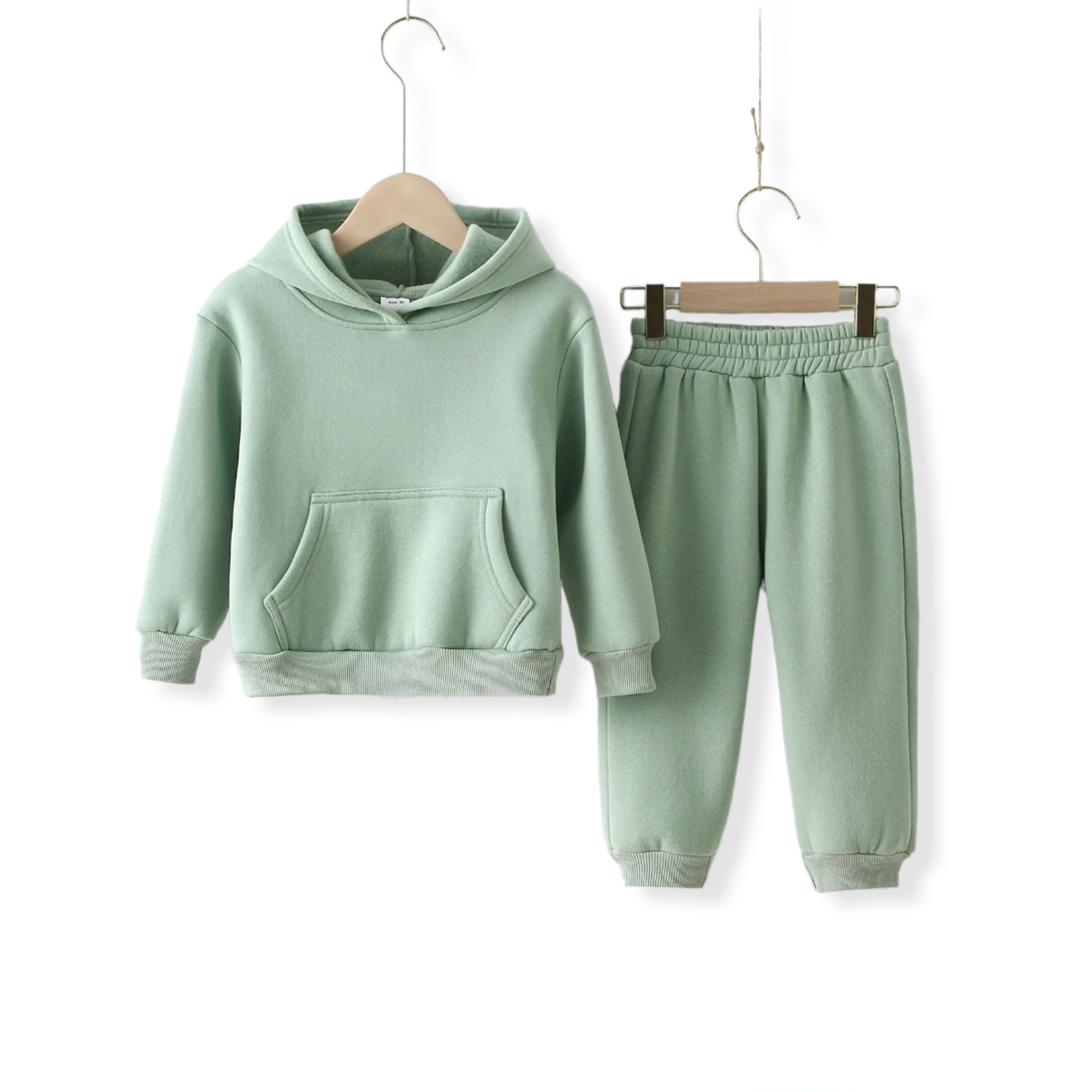Green mint warm unisex tracksuit for kids and toddlers hung on a hanger against a white wall from hunny bubba kids