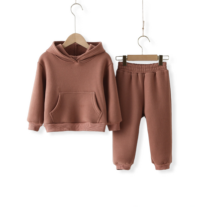 A Earth brown warm unisex tracksuit for kids and toddlers hung on a hanger against a white wall from hunny bubba kids
