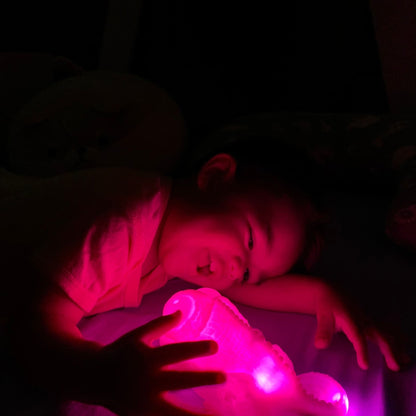 baby smiling and enjoying his night lamp lit up in pink - hunny bubba kids