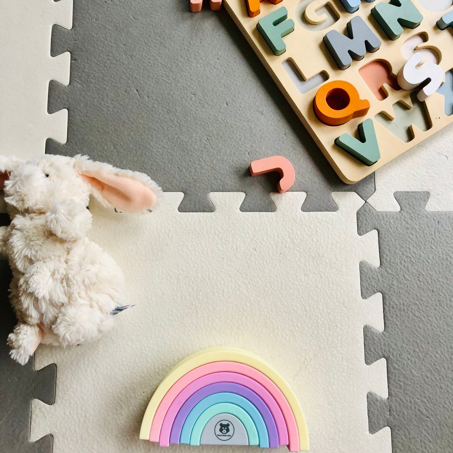 rainbow stacking toy laying in nursery floor - hunny bubba kids