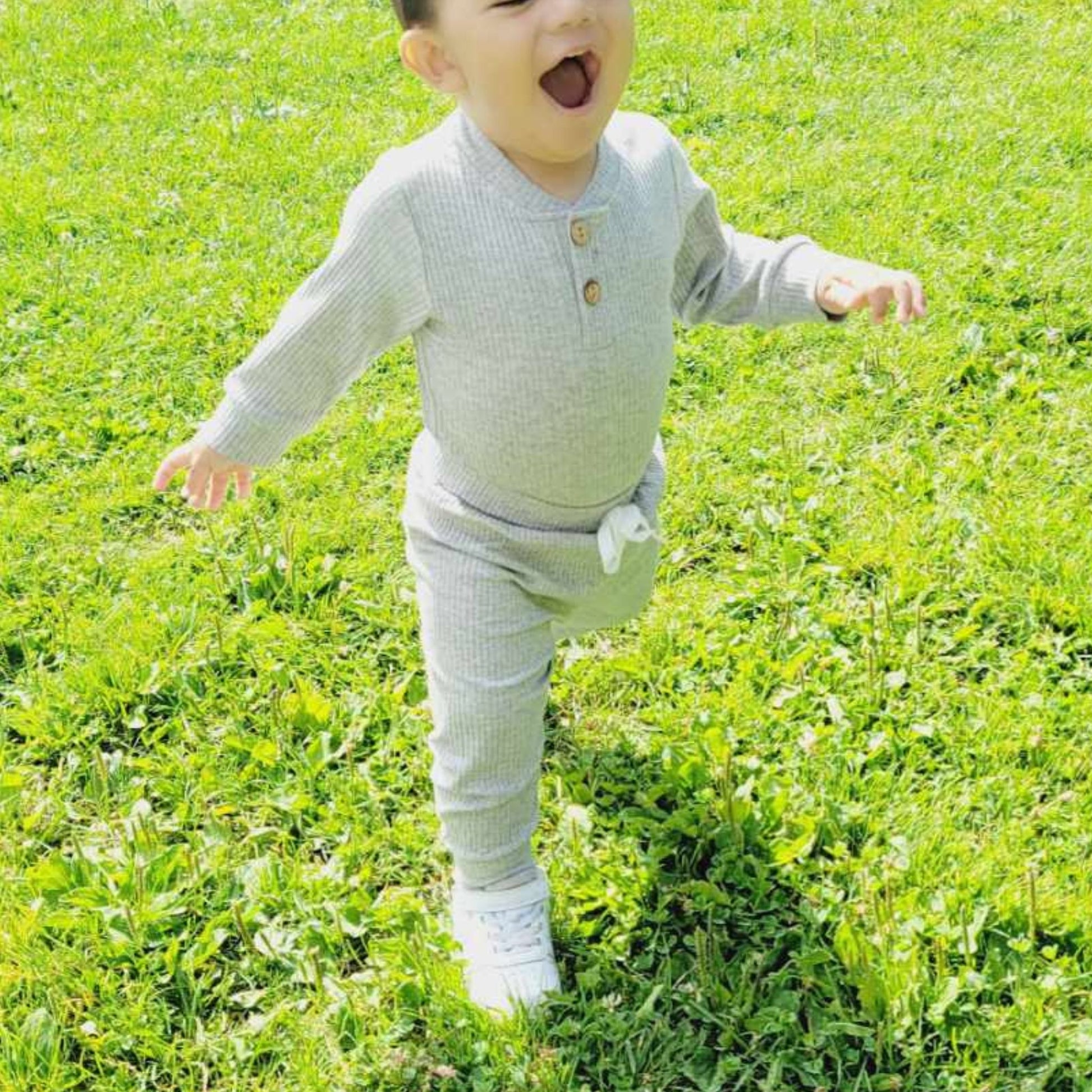 baby running and smiling while wearing unisex tracksuit for kids- hunny bubba kids