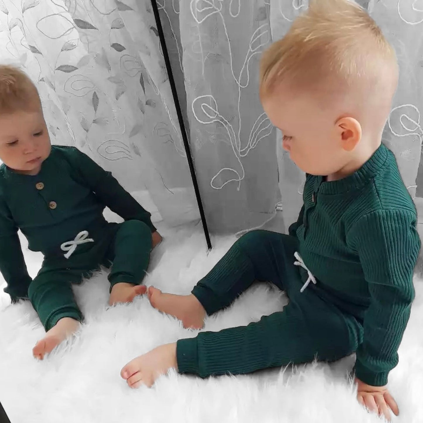 baby wearing a green two-piece suit in his room- hunny bubba kids